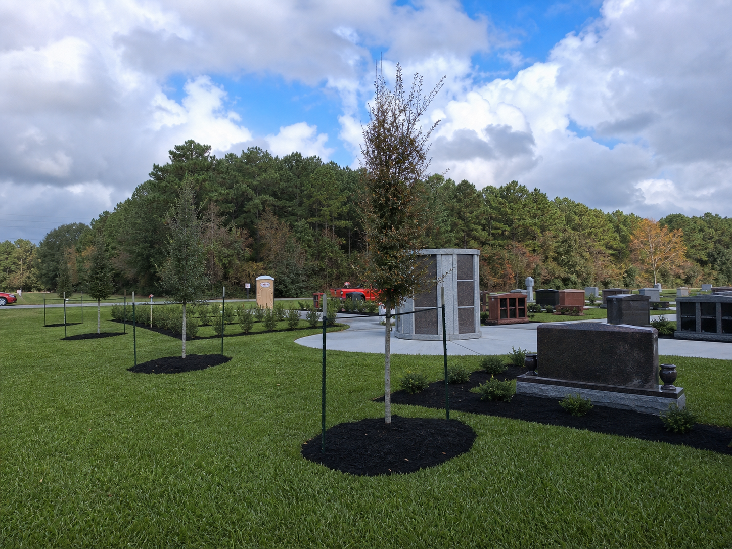 Completed cemetery expansion with healthy green grass, trees, shrubs, and walkways